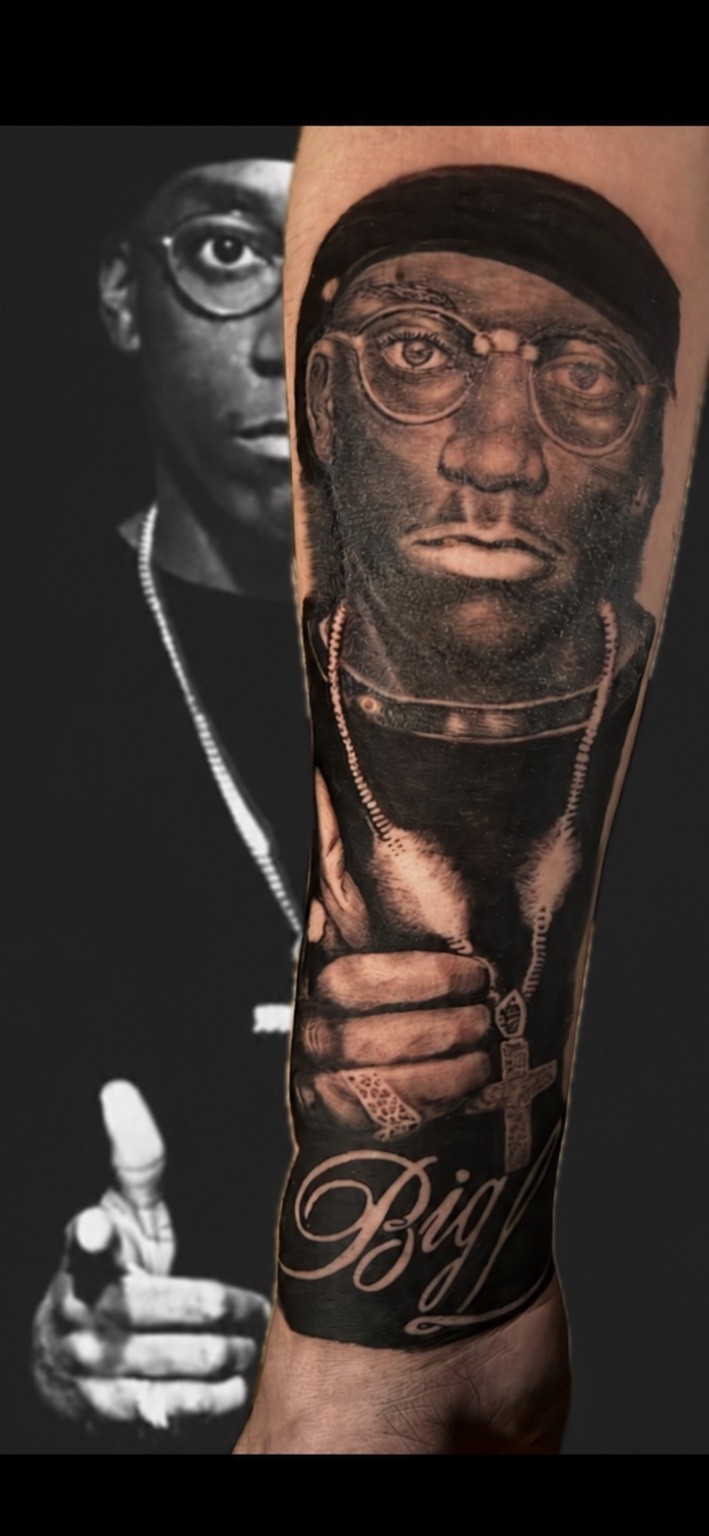 Black and grey portrait tattoo alongside the reference photograph